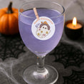 Load image into Gallery viewer, Boo Halloween edible drink topper on a glass of spooky purple cocktail with pumpkin in the background.