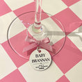 Load image into Gallery viewer, Wine glass with a 'Baby Brannan' tag on a pink and white checkered background