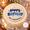Load image into Gallery viewer, A close-up of a frothy beverage in a gold-rimmed glass, topped with foam printed with the words “Happy Birthday” and “Mike’s 60th Birthday” in blue and light blue lettering, with a small pink brand watermark in the lower right corner.