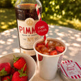 Load image into Gallery viewer, Summer Pimm's & Strawberries Paper Straw Toppers with Pimm's drink and fresh strawberries in the background.