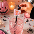 Load image into Gallery viewer, Hand holding a Halloween Paper Straw Topper saying 'Boo!' in a drink at a festive Halloween party.