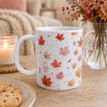 Load image into Gallery viewer, Cosy Season Autumn Drinking Mug with colorful leaf designs on a cozy table setting.
