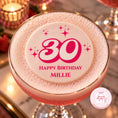 Load image into Gallery viewer, A pink cocktail in a coupe glass with a thick white foam top, decorated with a round white topper printed with a pink '30 Happy Birthday Millie' design. The glass is set on a marble surface with warm, blurred background lights and candles.
