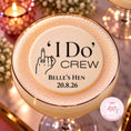 Load image into Gallery viewer, A close-up of a customised cocktail in a coupe glass with a gold rim, topped with thick foam featuring a custom printed design that reads "I Do Crew" and "Belle's Hen" with a date. The background is softly blurred with warm candlelight and floral decor.