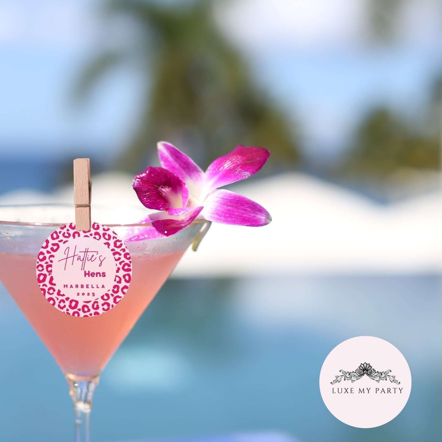 Personalised edible cocktail toppers on a pink drink with a flower and decoration by Luxe My Party.