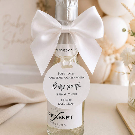 white pre-tied satin bows 10cm pack of 6 adorning a bottle for a baby shower celebration.