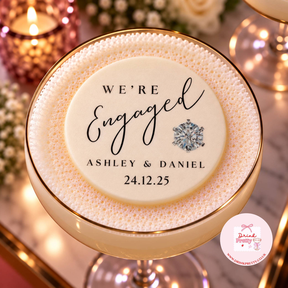 A close-up of a round white foam-covered drink topped with a printed 'We're Engaged Ashley & Daniel 24.12.