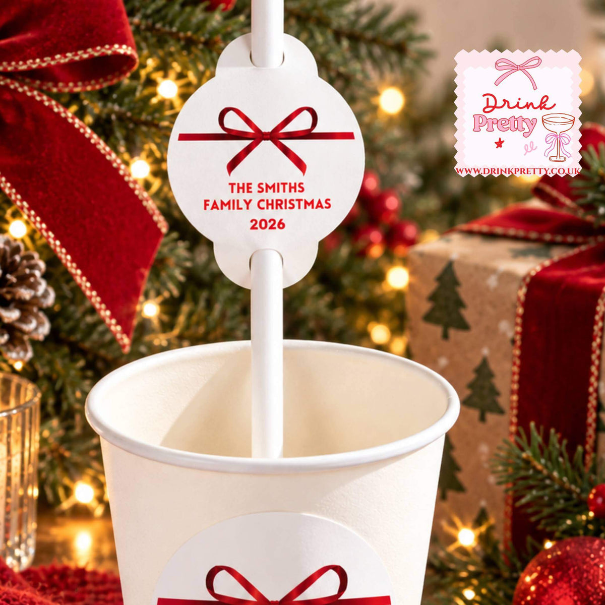 Personalised Christmas Straws With Red Bow Toppers displayed in a festive cup with custom name tag and red bow.