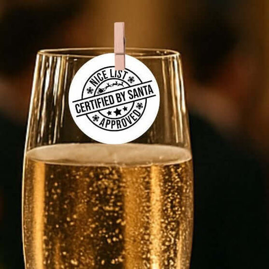 Santa's Nice List Christmas edible cocktail toppers on a champagne glass with a tag that says 'Certified by Santa'.