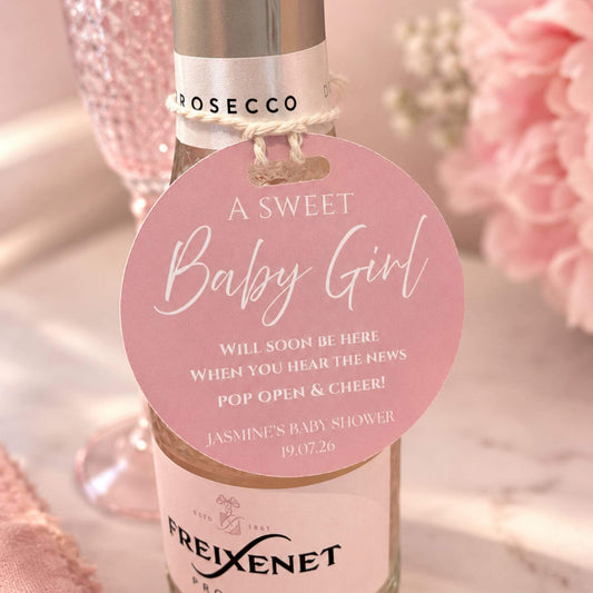 Baby Shower Pop The Fizz bottle favour tags attached to a prosecco bottle, perfect for celebrations.