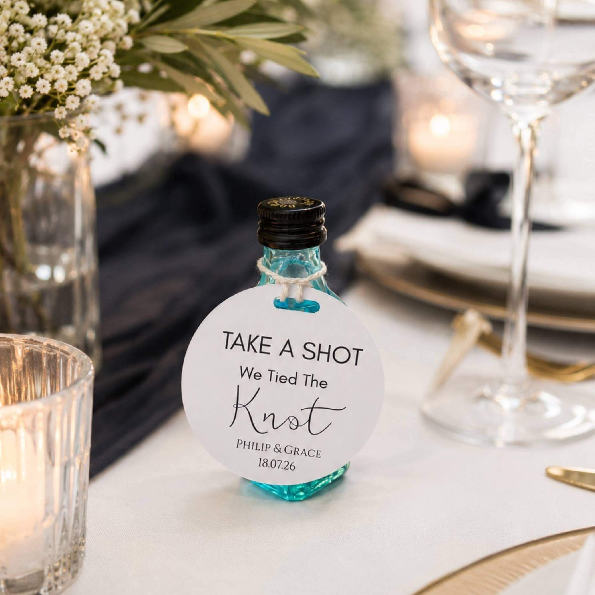 Take A Shot wedding favour bottle tags on a beautifully set wedding table with decorations.