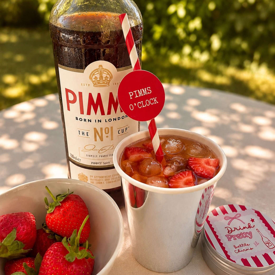 Summer Pimm's & Strawberries Paper Straw Toppers with Pimm's drink and fresh strawberries in the background.