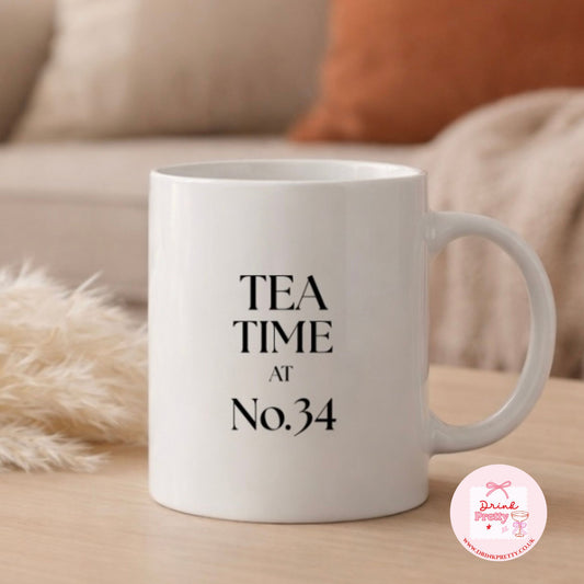 Personalised tea time mug with 'TEA TIME AT No.34' printed on a white ceramic background.
