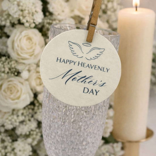 Happy Heavenly Mothers Day Edible Wafer Drink Toppers attached to a glass with flowers and candle in the background.