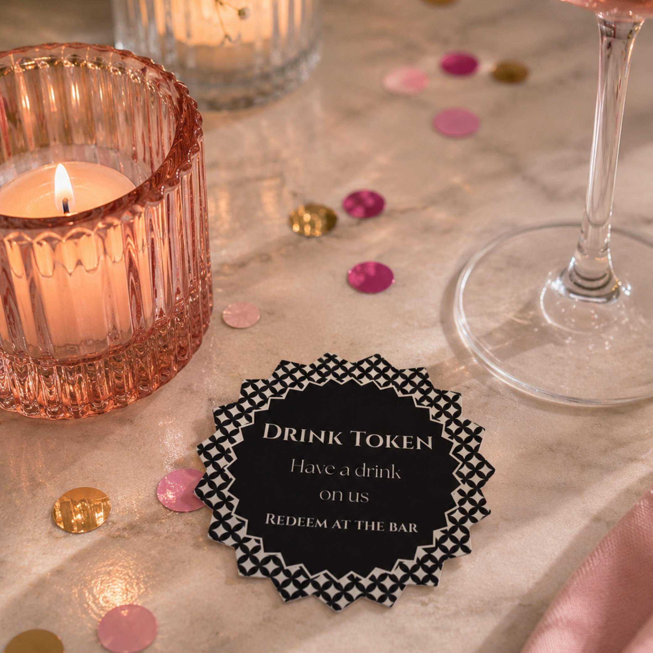 Black & White Diamond Drink Tokens on a festive table with candles and confetti, offering complimentary drinks to guests.