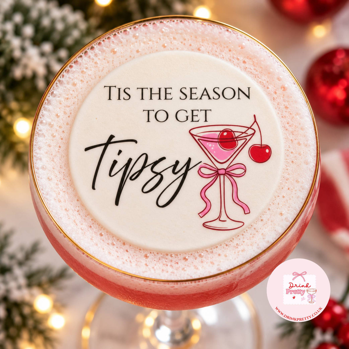 Tis The Season To Get Tipsy edible drink topper on a festive cocktail garnished with cherries.