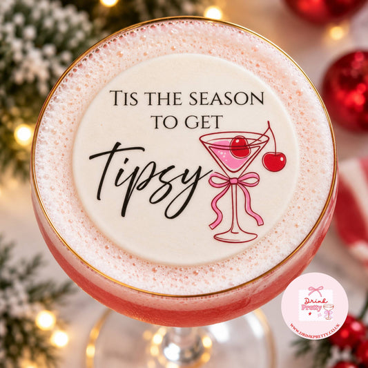 Tis The Season To Get Tipsy edible drink topper on a festive cocktail garnished with cherries.