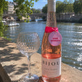 Load image into Gallery viewer, Rose Moments Bottle Charm Gift Tag on a bottle of rosé wine by the river with a crystal glass.
