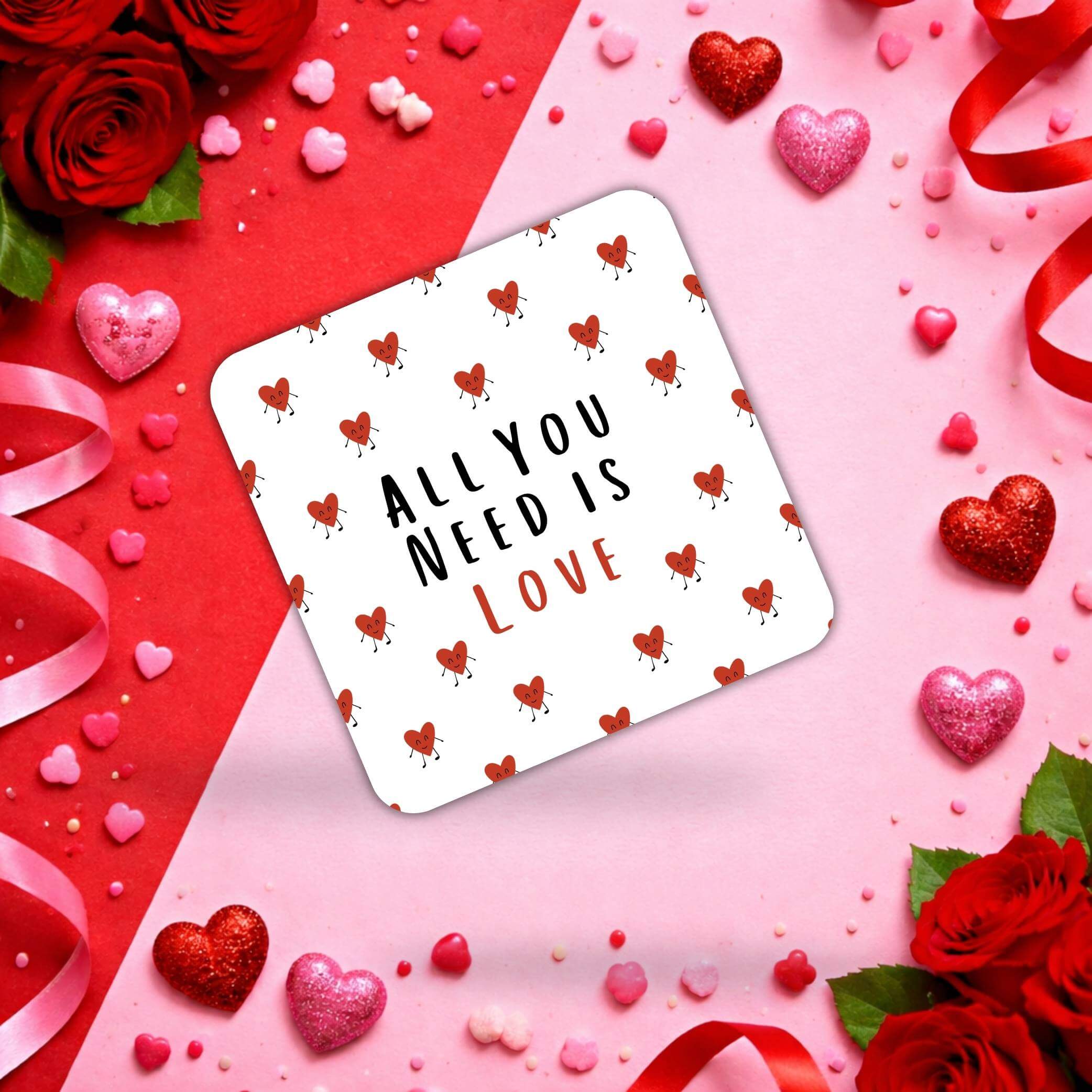 Valentine's day coasters featuring a design with hearts and the phrase 'All You Need Is Love' surrounded by decorations.